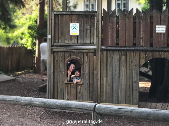 Sohn und Mama schauen aus der Spielplatzburg